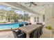 Outdoor patio area with a dining table and chairs, overlooking the screened-in pool and backyard at 204 S Trask St, Tampa, FL 33609