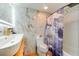 Bathroom featuring a modern vanity, marble-like walls, and stylish purple-themed shower curtain at 20921 Haulover Cv # 8, Lutz, FL 33558
