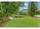 Lush green lawn and mature trees offer a tranquil setting with stunning lake views at 2238 Shirecrest Cove Way, Lutz, FL 33558