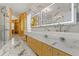 Luxurious bathroom with a walk-in shower, marble tile, and and vanity at 2238 Shirecrest Cove Way, Lutz, FL 33558