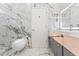 Elegant bathroom with marble walls, modern toilet and illuminated vanity mirror at 2238 Shirecrest Cove Way, Lutz, FL 33558