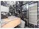 Sleek bathroom features black marble walls, floating sink with accent lighting and modern shelving unit at 2238 Shirecrest Cove Way, Lutz, FL 33558