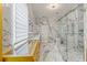 Bright bathroom with double vanity, marble floors and walls, and glass-enclosed shower at 2238 Shirecrest Cove Way, Lutz, FL 33558
