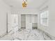 Bedroom featuring built-in closet system, marble floors, and modern light fixture at 2238 Shirecrest Cove Way, Lutz, FL 33558