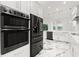 Modern kitchen with stainless steel appliances, marble floors and white cabinetry at 2238 Shirecrest Cove Way, Lutz, FL 33558