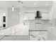 Open kitchen featuring a large island with marble countertop, white cabinets, and a modern aesthetic at 2238 Shirecrest Cove Way, Lutz, FL 33558
