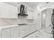 Modern kitchen featuring white cabinets, stainless hood, and marble backsplash at 2238 Shirecrest Cove Way, Lutz, FL 33558