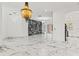 The open-concept living area showcases luxury marble floors, designer chandeliers, and sleek aesthetics at 2238 Shirecrest Cove Way, Lutz, FL 33558