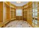 Walk-in closet featuring custom shelving, drawers, and marble floors at 2238 Shirecrest Cove Way, Lutz, FL 33558
