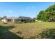 Large, grassy backyard with an enclosed pool area and mature trees creating a private setting at 22755 Cypress Trail Dr, Lutz, FL 33549