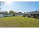 Large grassy backyard featuring a screened-in pool and privacy fence at 22755 Cypress Trail Dr, Lutz, FL 33549