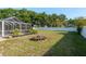 Spacious, fenced backyard with lush grass, a fire pit, and privacy landscaping at 22755 Cypress Trail Dr, Lutz, FL 33549