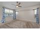 Bright and spacious bedroom features large windows, soft carpet, and a ceiling fan for added comfort at 22755 Cypress Trail Dr, Lutz, FL 33549
