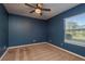 A vacant bedroom with a ceiling fan, brown carpet, and a window overlooking the outdoors at 22755 Cypress Trail Dr, Lutz, FL 33549