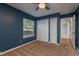 Bedroom with a view of outdoor landscaping, double closets and a glimpse of a wood floored hallway at 22755 Cypress Trail Dr, Lutz, FL 33549