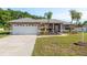 Charming single Gathering home featuring a well-maintained lawn, mature landscaping, and neutral color palette at 22755 Cypress Trail Dr, Lutz, FL 33549