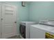 Laundry room with washer, dryer, utility sink, and door with a hanging rack at 22755 Cypress Trail Dr, Lutz, FL 33549