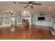 Spacious living room features hardwood floors, a stone fireplace, and a partial view of the kitchen at 22755 Cypress Trail Dr, Lutz, FL 33549