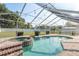 Sparkling pool and spa under a screened enclosure, surrounded by lush greenery at 22755 Cypress Trail Dr, Lutz, FL 33549