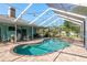 Relaxing screened-in pool and spa area with brick pavers and lush landscaping, perfect for outdoor enjoyment at 22755 Cypress Trail Dr, Lutz, FL 33549