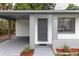 Welcoming front entrance with a well-lit carport and landscaped flower beds adding curb appeal at 2324 W Marquette Ave, Tampa, FL 33604