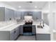 Modern kitchen featuring gray cabinets, stainless steel appliances, and white countertops at 2324 W Marquette Ave, Tampa, FL 33604