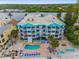 Aerial view of condo building with pool, lounge area, and waterfront access at 24 Gulf Blvd # 1C, Indian Rocks Beach, FL 33785