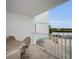 Outdoor balcony with table, chairs and railing overlooking the neighborhood street at 24 Gulf Blvd # 1C, Indian Rocks Beach, FL 33785