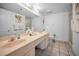 Bright bathroom featuring double vanity sinks, neutral tile flooring, and ample lighting at 24 Gulf Blvd # 1C, Indian Rocks Beach, FL 33785