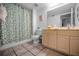 Well-lit bathroom with tiled floor, patterned shower curtain, and swan-shaped towel art at 24 Gulf Blvd # 1C, Indian Rocks Beach, FL 33785