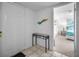 Bright entryway with white door, ceramic tile flooring, table, and view into the carpeted bedroom at 24 Gulf Blvd # 1C, Indian Rocks Beach, FL 33785