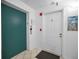 Hallway featuring a teal elevator door and a white entrance door at 24 Gulf Blvd # 1C, Indian Rocks Beach, FL 33785