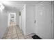 Long hallway with ceramic tile flooring, white walls, and white doors at 24 Gulf Blvd # 1C, Indian Rocks Beach, FL 33785