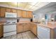 Open kitchen featuring classic appliances, wood cabinets and seamless counterspace at 24 Gulf Blvd # 1C, Indian Rocks Beach, FL 33785