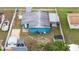Aerial view showcasing the home with a fenced backyard, lush greenery, and nearby boat storage at 2408 Wishing Well Way, Tampa, FL 33619