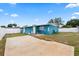 Exterior view of the teal-colored home with a concrete slab and fenced backyard at 2408 Wishing Well Way, Tampa, FL 33619