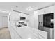Bright kitchen features white cabinetry, stainless steel appliances, and a sleek quartz countertop with bar seating at 2408 Wishing Well Way, Tampa, FL 33619