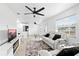 Open-concept living room featuring a ceiling fan, tile floors, and white walls, flowing into the kitchen area at 2408 Wishing Well Way, Tampa, FL 33619