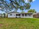 Exterior shot of the backyard featuring a large tree that provides some shade at 2432 Keene Park Dr, Largo, FL 33771