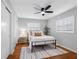 Comfortable bedroom features a cozy bed, a ceiling fan, and a view to the outside at 2432 Keene Park Dr, Largo, FL 33771