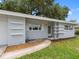 Close-up of the home's entrance featuring a tidy walkway and unique shelving accents on a freshly painted exterior at 2432 Keene Park Dr, Largo, FL 33771