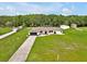 Expansive aerial view of a home with a long driveway, mature trees, and a spacious green lawn at 25555 Oaks Blvd, Land O Lakes, FL 34639