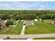 Wide aerial view showcasing a property with large yard, outbuildings, and a long private driveway at 25555 Oaks Blvd, Land O Lakes, FL 34639