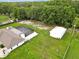Large property features a screened pool, storage buildings, mature trees, and a well-maintained lawn at 25555 Oaks Blvd, Land O Lakes, FL 34639