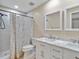 Bathroom featuring a shower with floral shower curtain, dual mirrors, and modern fixtures at 25555 Oaks Blvd, Land O Lakes, FL 34639