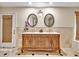 Stylish bathroom featuring a double vanity with ornate detailing, designer mirrors, and elegant lighting fixtures at 25555 Oaks Blvd, Land O Lakes, FL 34639