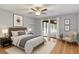 Cozy bedroom with warm hardwood floors, a comfortable bed, and sliding glass doors to a covered patio at 25555 Oaks Blvd, Land O Lakes, FL 34639