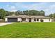 Charming single-story home featuring a lush green lawn, dark garage door, and well-maintained landscaping at 25555 Oaks Blvd, Land O Lakes, FL 34639