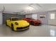 Spacious garage showcasing a yellow Porsche and a red Corvette at 25555 Oaks Blvd, Land O Lakes, FL 34639