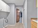 Hallway with neutral walls leading to a door and cabinets at 25555 Oaks Blvd, Land O Lakes, FL 34639